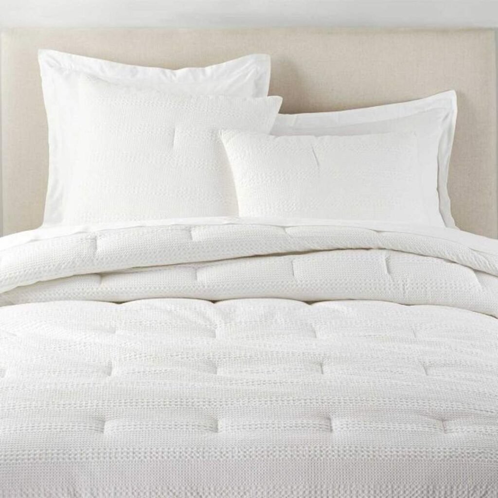 Soft white comforter bedding set with pillows, designed for modern home furnishing to provide comfort, elegance, and a luxurious sleeping experience.